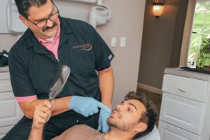 Dr. Anthony Lordo with patient holding dental mirror